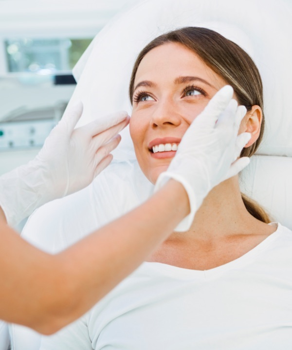 Smiling woman being examined by dermatologist